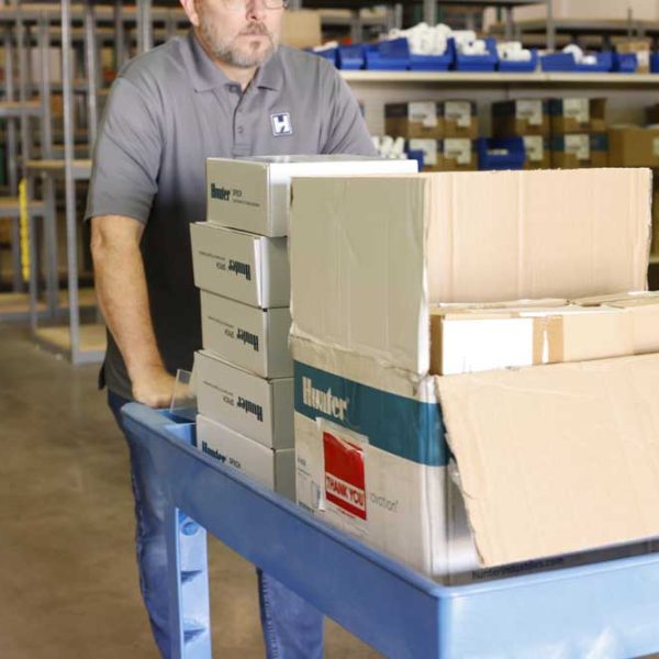 A man walking out of an irrigation station store with supplies